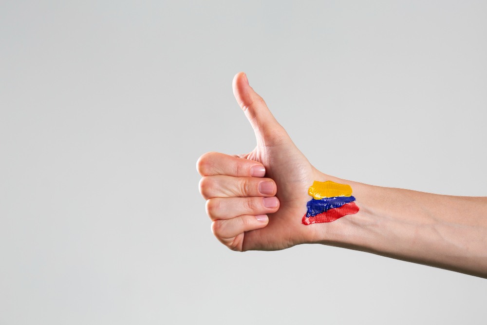 una mano con una bandera de Colombia pintada